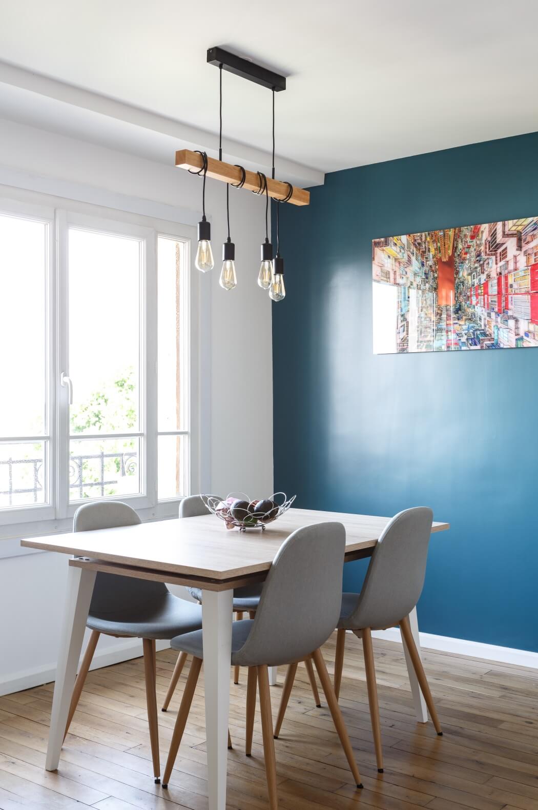 L'espace repas au style scandinave, avec un pan de mur couleur vert canard et un joli parquet