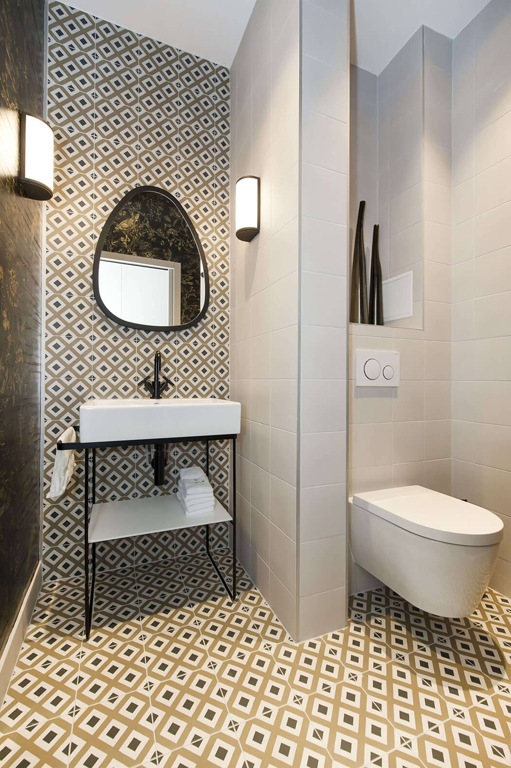 salle de bain haut de gamme très tendance avec carreaux de ciment, appliques murales et wc suspendus